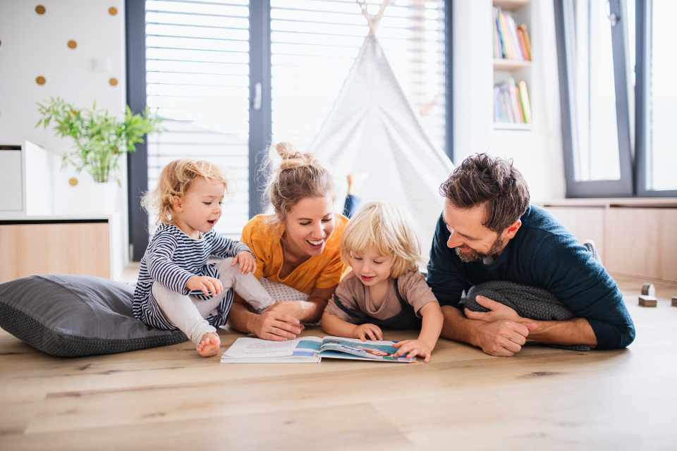 family reading book together on newly installed hardwood flooring